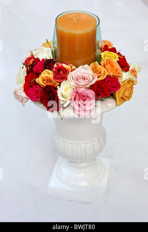 Arrangement de roses avec une bougie sur blanc Banque D'Images