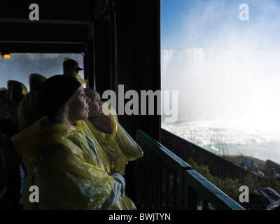 Mère et sa fille âgée de deux ans à regarder les chutes Niagara cascade Horseshoe à partir de la plate-forme ci-dessous. L'Ontario, Canada. Banque D'Images