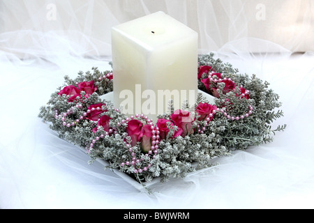 Arrangement floral avec une bougie sur blanc Banque D'Images