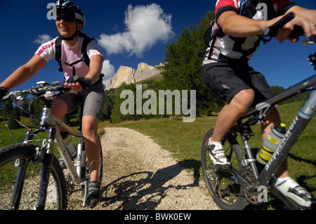Jeune couple riding mountain bikes sous le ciel bleu, le Tyrol du Sud, Italie, Europe Banque D'Images