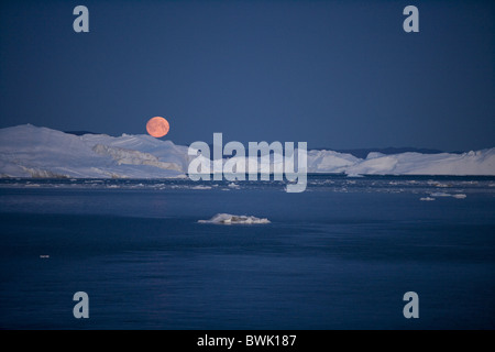 Pleine lune sur l'icebergs d'Ilulissat Icefjord Kangerlua au crépuscule, Jakobshavn Ilulissat (), la baie de Disko, Kitaa, Groenland Banque D'Images