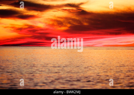 Nuages coucher de soleil spectaculaire sur l'eau calme. Banque D'Images