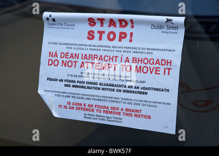 Panneau d'avertissement stop bilingue en gaélique irlandais et anglais pour stationnement en infraction en république d'Irlande Dublin Banque D'Images