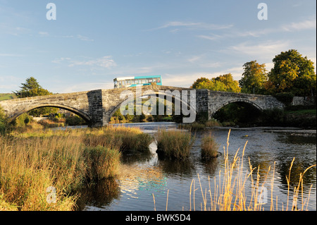 Bus arriva traverse la rivière Conwy sur le Pont Fawr bridge dans la vieille ville de Conwy dans la vallée de Conwy, Gwynedd, Pays de Galles, Royaume-Uni Banque D'Images