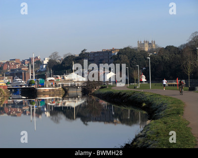 Canal d'Exeter avec vue sur cathédrale en arrière-plan Exe valley randonnée à vélo avec les randonneurs cyclistes Devon UK Banque D'Images