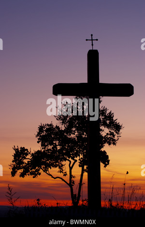 Croix de bois en bordure de symbole avant que bush catholique. En arrière-plan on peut voir le coucher du soleil coloré Banque D'Images