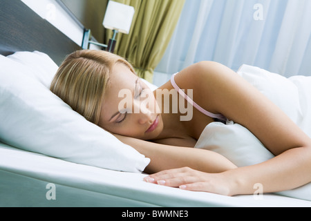 Photo de jolie femme dormir paisiblement dans un lit blanc Banque D'Images