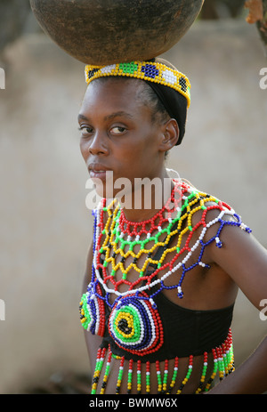 Filles zoulous robe perlée traditionnelle et l'exécution sur leurs têtes des pots, village zoulou de Shakaland, Kwazulu Natal, Afrique du Sud Banque D'Images