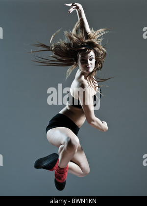 Beau young caucasian woman girl ballet danseur breakdance leap saut sur studio isolated background Banque D'Images