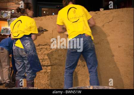 Paris, France, salon professionnel, 'salon Batir Ecologique', Green Building Products, deux personnes par derrière, couvrant le mur de paille avec de la boue, isolation de la maison économe en énergie, construction écologique Banque D'Images