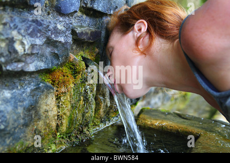 Source de l'eau de source potable femme en montagne de Pyrénées Banque D'Images
