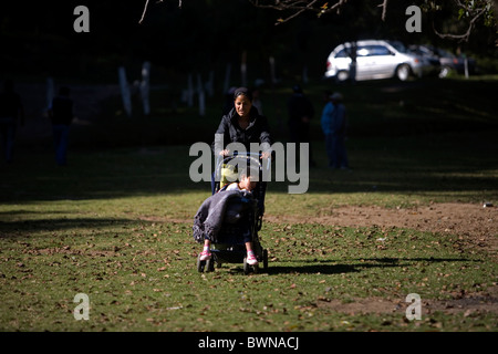 Adriana Lopez, 23, porte sa fille Citlatli Lopez, 6, qui a un kyste cérébral dans un parc public dans la ville de Mexico, le 28 octobre Banque D'Images