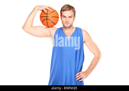 Jeune joueur de basket-ball Basket-ball debout et tenant un Banque D'Images