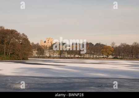 Wollaton Hall illustrée de l'autre côté du lac, qui est gelé et dispose d'une fine couche de neige sur le dessus de la glace, Nottingham (Angleterre) Banque D'Images