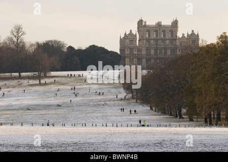 Parc de Wollaton Hall Wollaton avec en arrière-plan dans la neige avec les gens de la luge en bas de la colline Nottingham England UK Banque D'Images