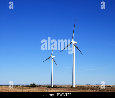 Deux moulins à vent blanc électrique ou d'éoliennes sur une prairie avec fond de ciel bleu et copy space Banque D'Images