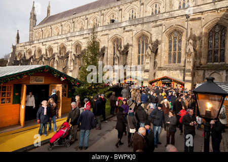 La foule profiter des boutiques du marché de noël bu la cathédrale de Winchester Banque D'Images