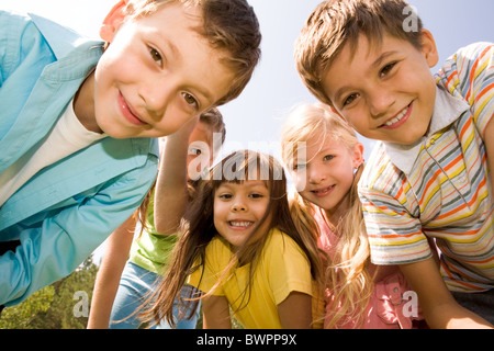 Photo de heureux les filles avec de beaux mecs en face smiling at camera Banque D'Images