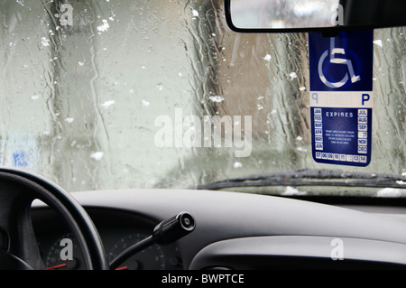 Une étiquette d'handicapés est suspendu le rétroviseur d'un véhicule stationné sur un jour de pluie neige à Olympia, Washington. Banque D'Images