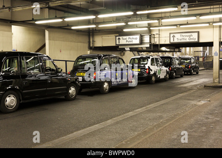 London's iconic des taxis sont disponibles pour les clients potentiels à la station de taxis à la gare de Euston, Londres. Banque D'Images