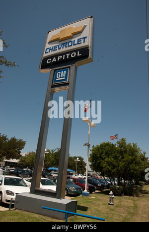 Grand Capital signe sur Chevrolet Chevy montre les normes et logos de General Motors en face de concession à Austin, Texas, États-Unis Banque D'Images