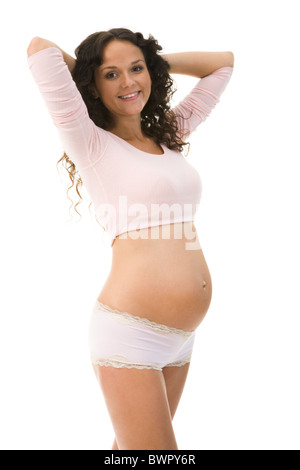 Photo de happy pregnant woman posing avant appareil photo sur fond blanc Banque D'Images