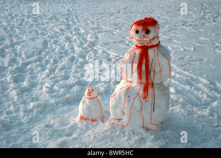 Un 'cartoon' bonhomme avec son chien, fait de la neige et de la laine, debout dans les prés à Édimbourg, Écosse, Royaume-Uni. Banque D'Images