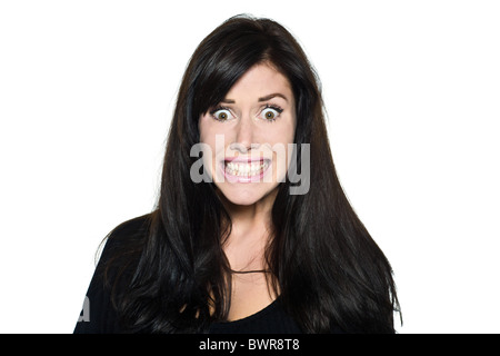 Studio shot portrait isolé sur fond blanc d'une belle femme peur stress dents sourire grimace drôle Banque D'Images