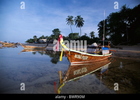 Les pêcheurs traditionnels bateaux longtail ancrés au large de la plage d'un village de pêcheurs dans le sud de la Thaïlande. Banque D'Images