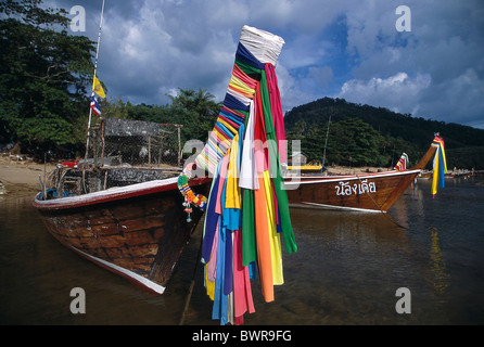 Les pêcheurs traditionnels bateaux longtail ancrés au large de la plage d'un village de pêcheurs dans le sud de la Thaïlande. Banque D'Images