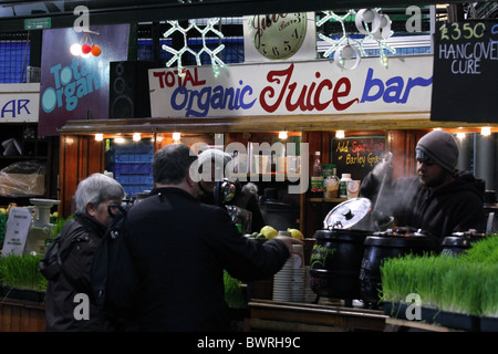 L'achat d'une boisson chaude au bar à jus biologiques à Borough Market, London Bridge, Angleterre Banque D'Images