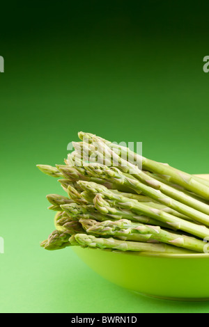 Gerbe d'asperges sur un fond vert. Banque D'Images