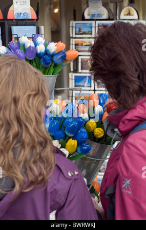 Les touristes à la recherche de cartes postales et souvenirs en vente à l'extérieur d'un magasin à Delft aux Pays-Bas Banque D'Images