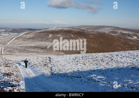 Une femme marche en hiver sur Moel y Gamelin au-dessus en Llangollen Clwyd, Nord du Pays de Galles Banque D'Images