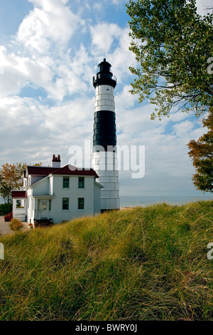 Beaux nuages flottent par Michigan's grand phare de Sable (1867) et le lac Michigan à Ludington State Park. Banque D'Images
