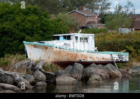 Un bateau abandonné de rouilles sur les rives d'un fleuve en raison de lois de restriction de la pêche en Nouvelle-Écosse, Canada. Banque D'Images