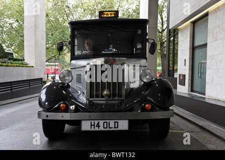 Un taxi londonien sous licence d'Asquith,attendre patiemment pour un tarif sur le rang de l'hôtel Intercontinental près de Hyde Park Corner. Banque D'Images