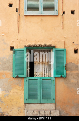 Volets verts sur une porte sur un bâtiment jaune, Tropea, Italie Banque D'Images