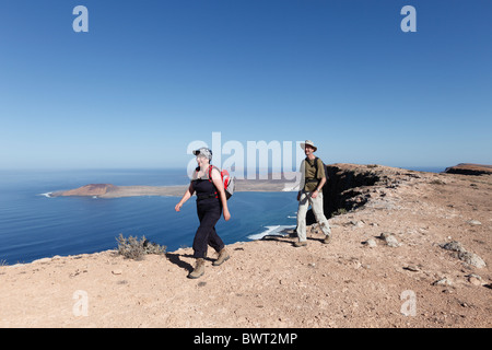 Randonneurs à Risco de Famara près de Guinate, en face de l'île de La Graciosa, Lanzarote, Canary Islands, Spain, Europe Banque D'Images