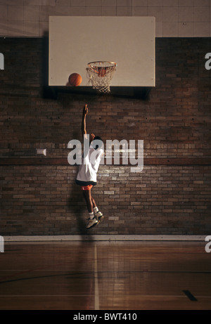 Jeune garçon pratiquant le tir de basket-ball. Banque D'Images