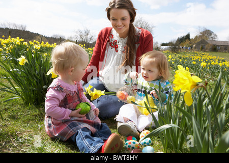 Mère et fille dans le champ de la Jonquille avec oeufs de Pâques décorés Banque D'Images