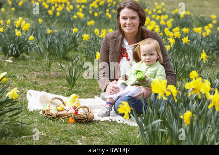 Mère et fille dans le champ de la Jonquille avec oeufs de Pâques décorés Banque D'Images