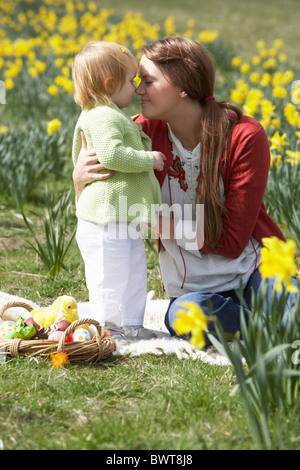 Mère et fille dans le champ de la Jonquille avec oeufs de Pâques décorés Banque D'Images