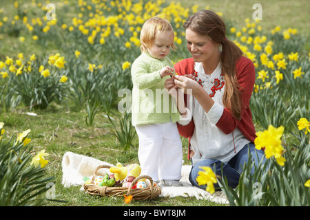 Mère et fille dans le champ de la Jonquille avec oeufs de Pâques décorés Banque D'Images