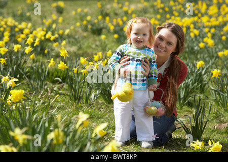 Mère et fille dans le champ de la Jonquille avec oeufs de Pâques décorés Banque D'Images