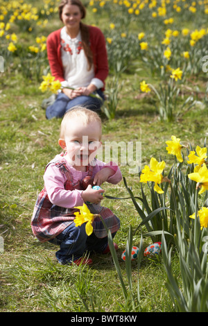 Mère et fille dans le champ de la Jonquille avec oeufs de Pâques décorés Banque D'Images