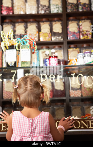 Heureux Girl standing in Sweet Shop Banque D'Images