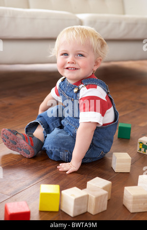 Jeune garçon jouant avec des blocs de couleur à la maison Banque D'Images