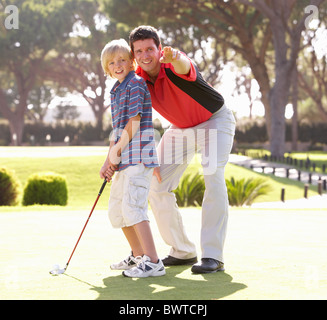 L'enseignement du père fils jouer au golf sur le putting green Banque D'Images