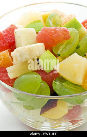 Salade de fruits frais mélanger comme libre dans un bol sur fond blanc Banque D'Images